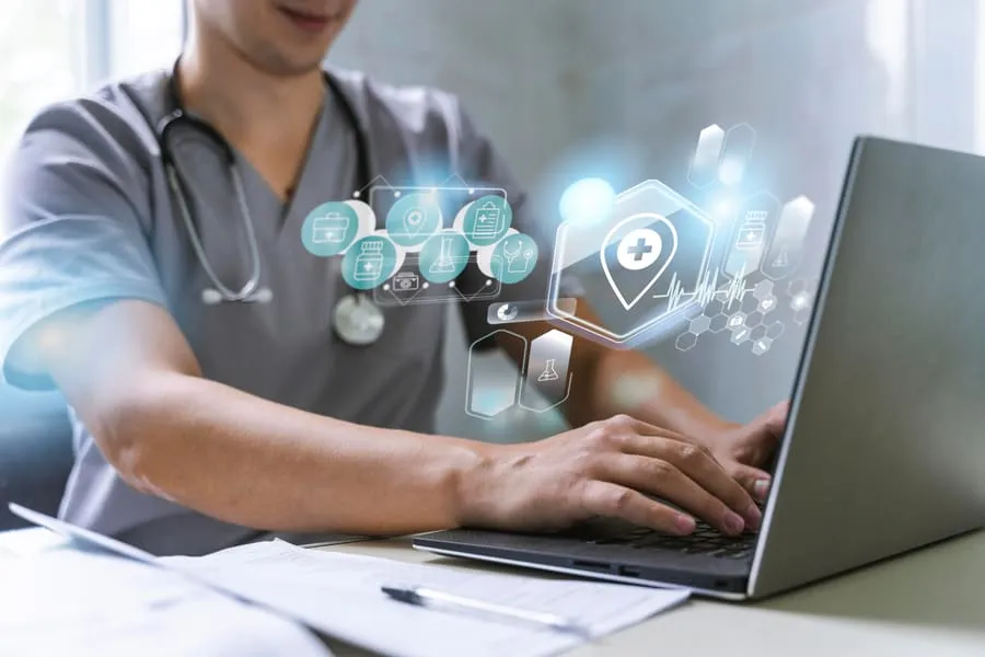 A healthcare professional using a laptop surrounded by holographic medical icons